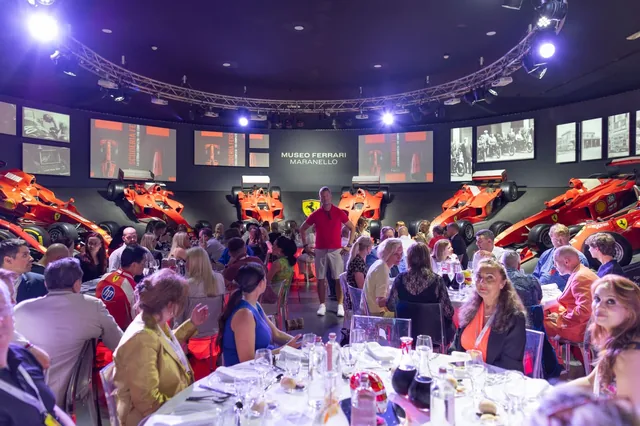 JT Foxx with guests surrounded by Ferrari race cars at the Ferrari Museum in Maranello